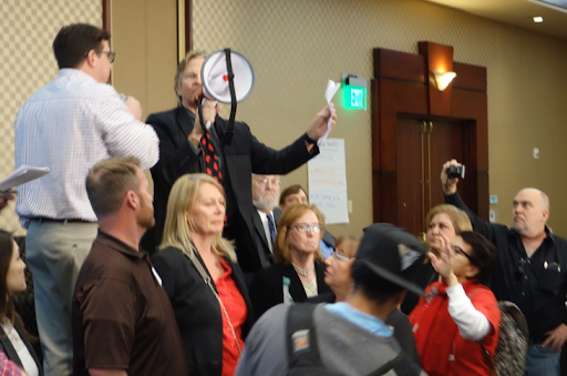 Matt Pakucko, president of Save Porter Ranch, uses a bullhorn to disrupt and take over a meeting of state regulators in February 2017