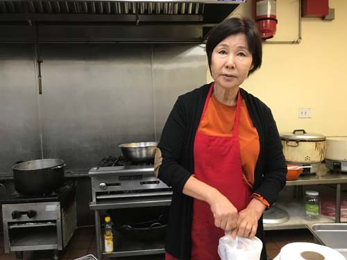 Hyun Sook Lee cleans up after making sandwiches at Glory Church of Jesus Christ in downtown L.A.