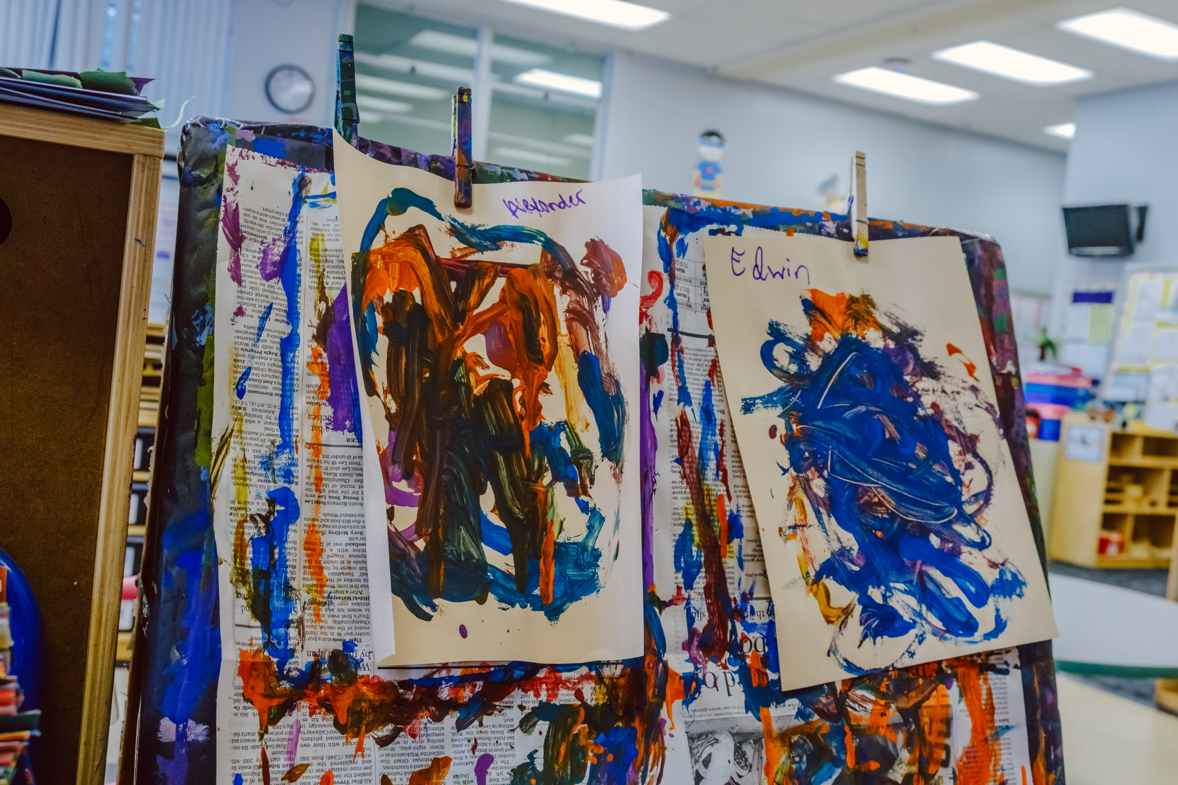 Paint-covered easels display the works of two students at the Pacific Avenue Education Center in Glendale. (Chava Sanchez/LAist)