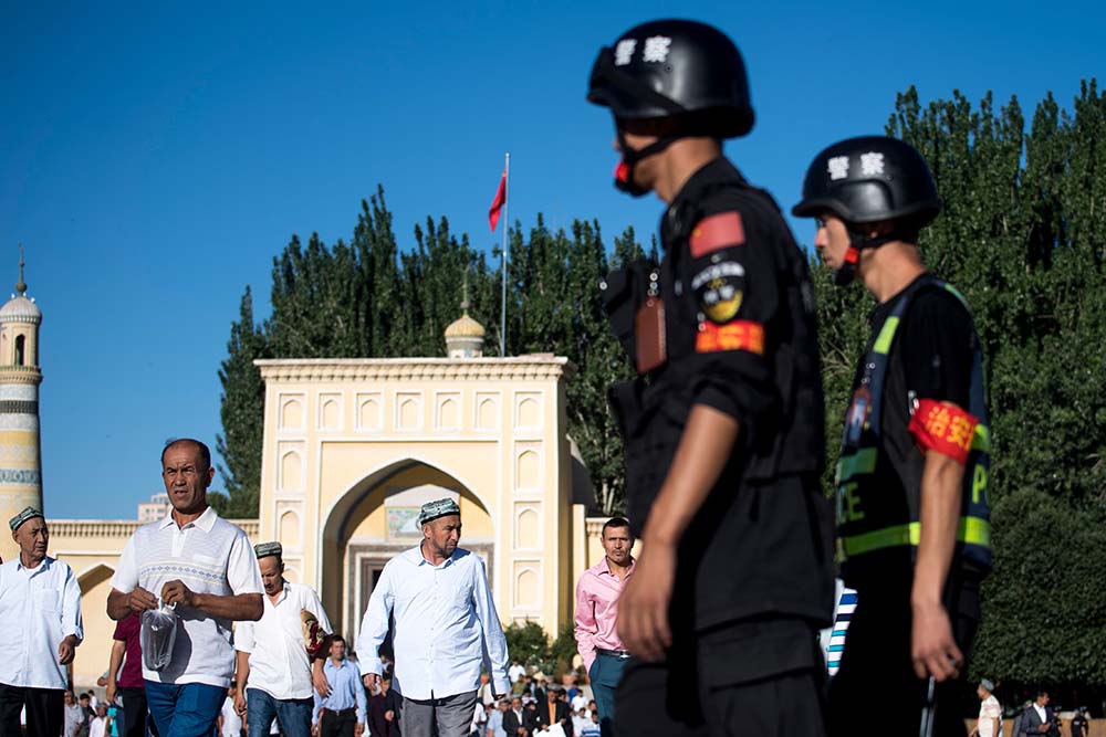 Police patrolling as Muslims leave the Id Kah Mosque after the morning prayer on Eid al-Fitr in the old town of Kashgar in China's Xinjiang region on June 26, 2017.