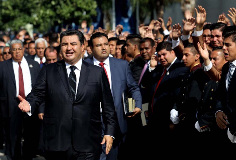 The leader of the Church of the Light of the World, Naason Joaquin Garcia (left), walking among his parishioners in Guadalajara, Mexico in August 2017.