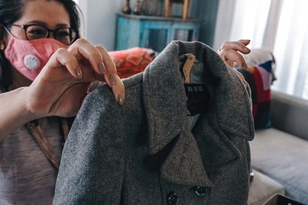 Kim Luu-Ng displays a coat her father bought her when the family left Vietnam by boat and arrived in Hong Kong as refugees.