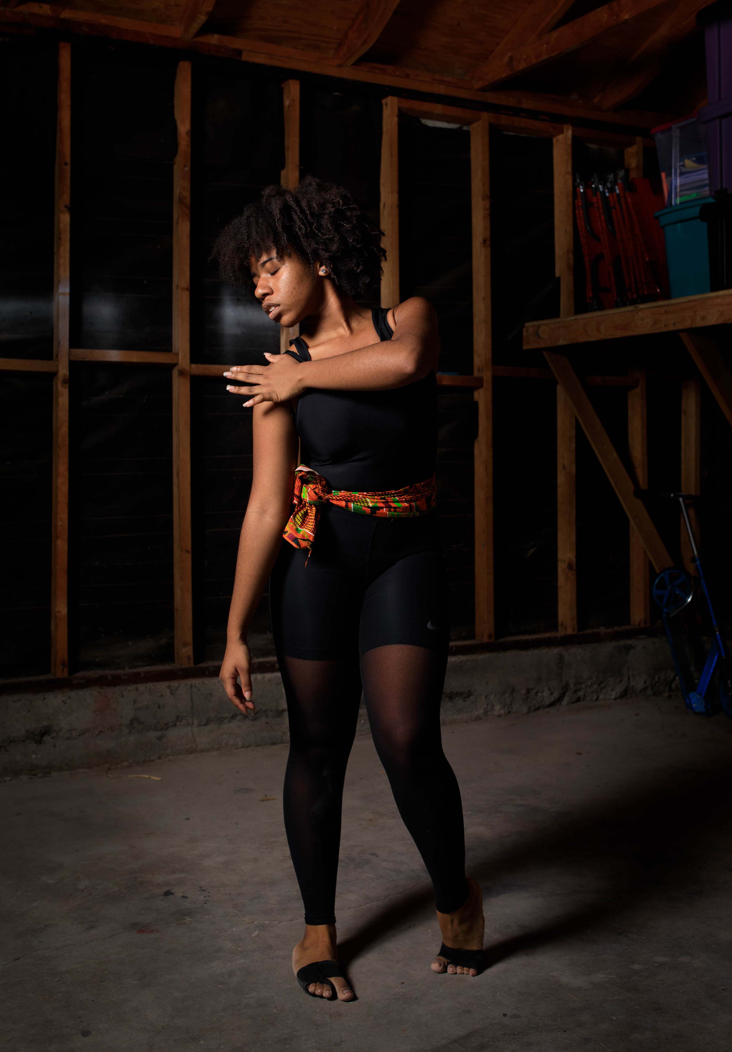 Aiyana D’Abriel performs her thesis choreography in the garage of her family home, instead of on stage with an ensemble of dancers. 