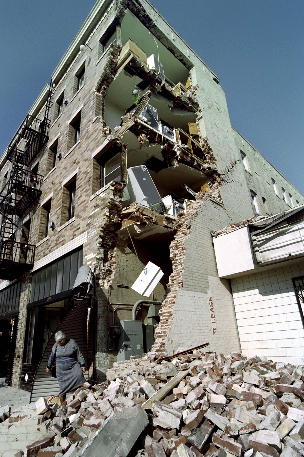 Aykui Alaverdyan walks over rubble after taking some of her belongings from her Hollywood Boulevard apartment building on January 20, 1994 that was destroyed in the Northridge earthquake. Thousands of Angelenos were driven from their home following the 6.7 magnitude quake.